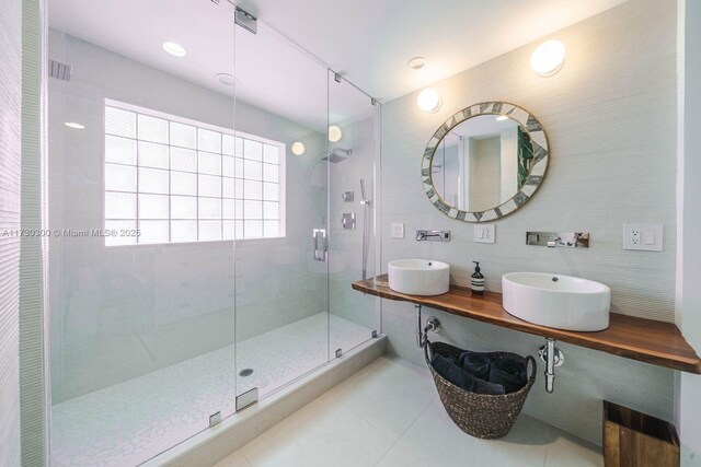 bathroom with sink, tile walls, tile patterned floors, and a shower with shower door