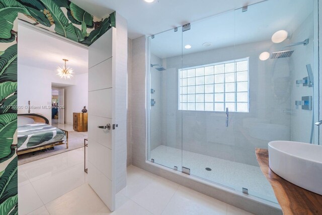 bathroom with a shower with door and tile patterned floors