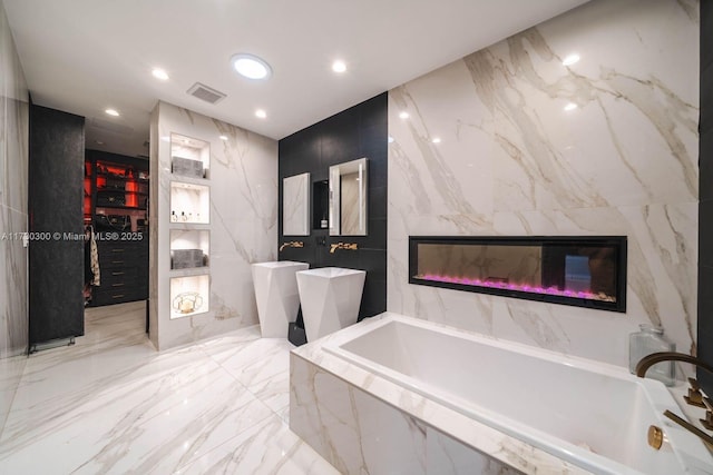 bathroom featuring a relaxing tiled tub and a fireplace