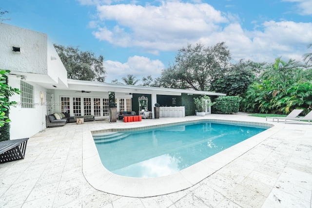 view of pool with french doors, ceiling fan, and a patio area