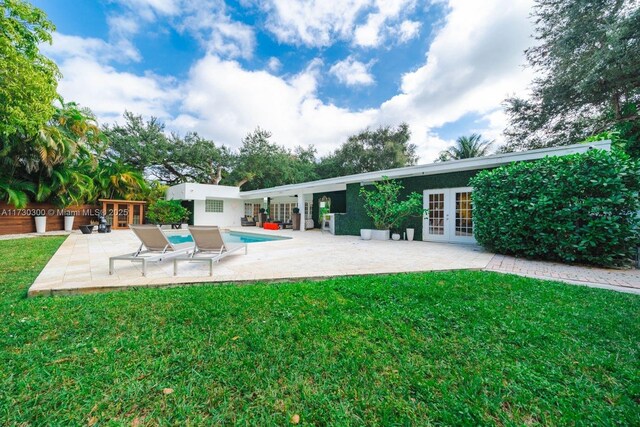 back of house with a lawn, a patio area, and french doors