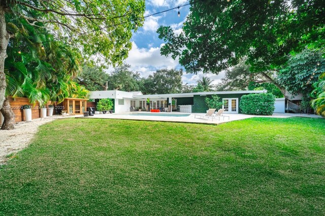 view of swimming pool with french doors, an outdoor structure, and a patio area