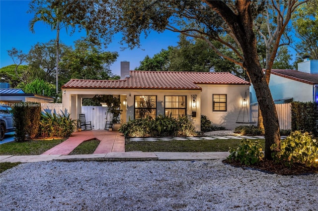 mediterranean / spanish home featuring a carport