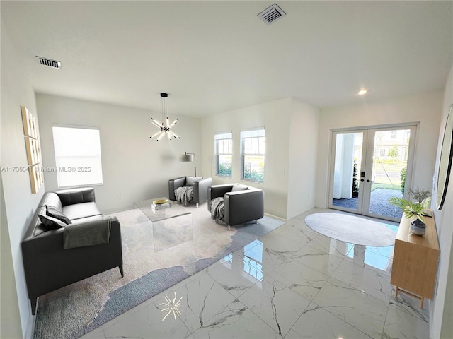 living room with a notable chandelier and french doors