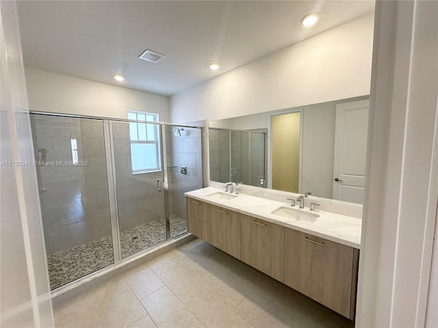 bathroom with vanity, a shower with door, and tile patterned flooring