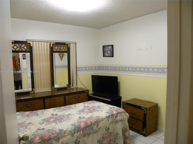 bedroom featuring a textured ceiling and light tile patterned floors