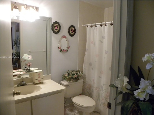 bathroom with toilet, a shower with shower curtain, and vanity