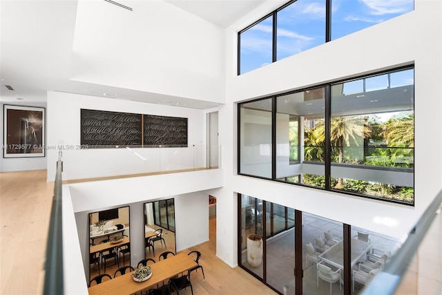 interior space featuring a towering ceiling and wood-type flooring