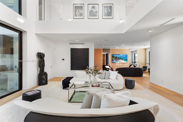 living room featuring a high ceiling and light hardwood / wood-style flooring