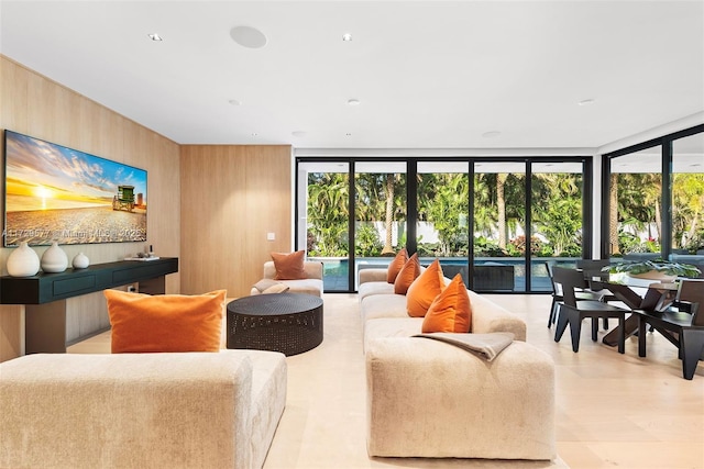 living room with wood walls and floor to ceiling windows