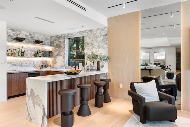 bar with light wood-type flooring