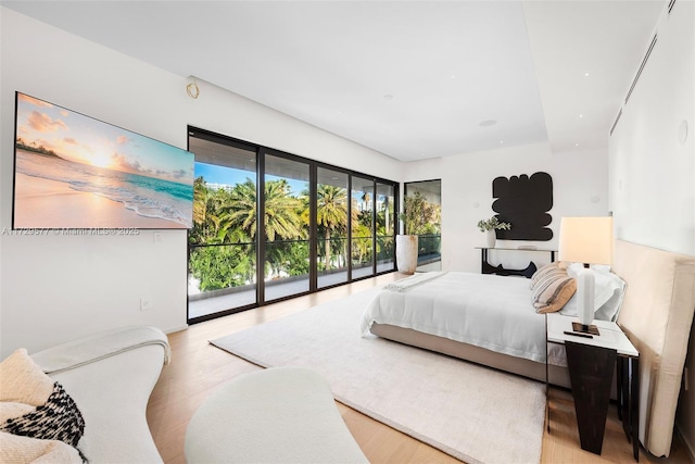 bedroom with light wood-type flooring and access to exterior