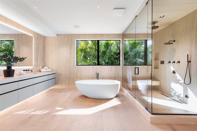 bathroom with vanity, shower with separate bathtub, and hardwood / wood-style floors