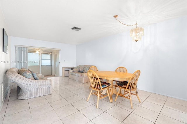 tiled dining area featuring an inviting chandelier