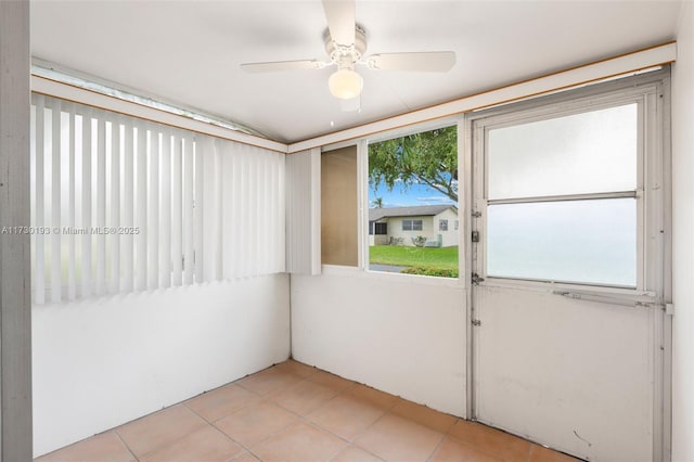 empty room featuring ceiling fan, a wealth of natural light, and light tile patterned floors