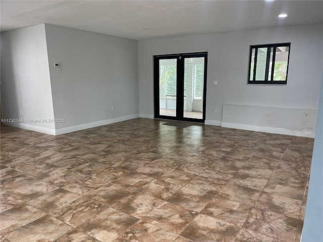 unfurnished room featuring a wealth of natural light and french doors