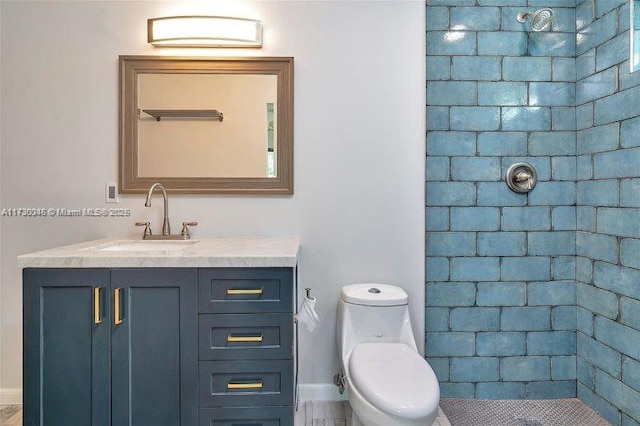 bathroom featuring tiled shower, vanity, and toilet