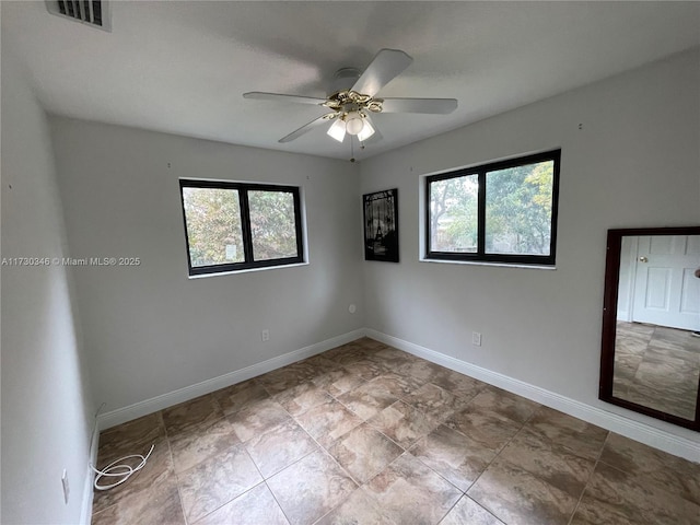 unfurnished room featuring ceiling fan and a healthy amount of sunlight