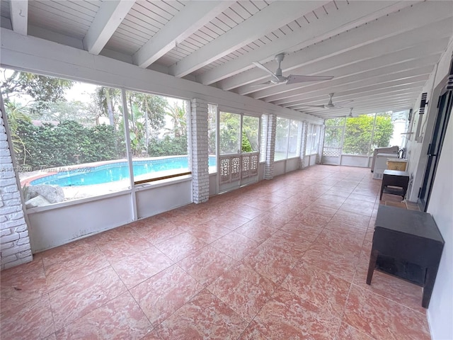 unfurnished sunroom featuring ceiling fan and beam ceiling