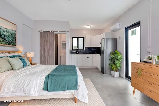 bedroom with sink, ensuite bath, stainless steel refrigerator, a barn door, and an AC wall unit