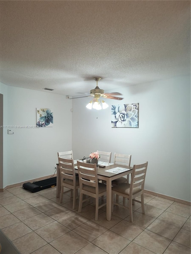 tiled dining room with ceiling fan and a textured ceiling