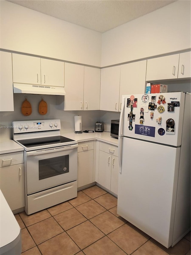 kitchen featuring white appliances, light tile patterned floors, and white cabinets