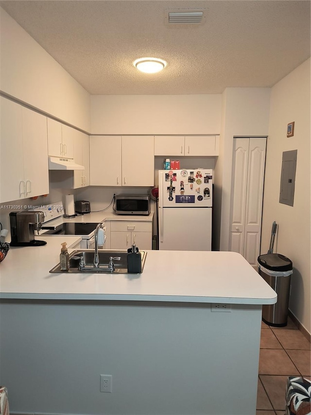 kitchen with white cabinetry, white appliances, electric panel, kitchen peninsula, and a textured ceiling