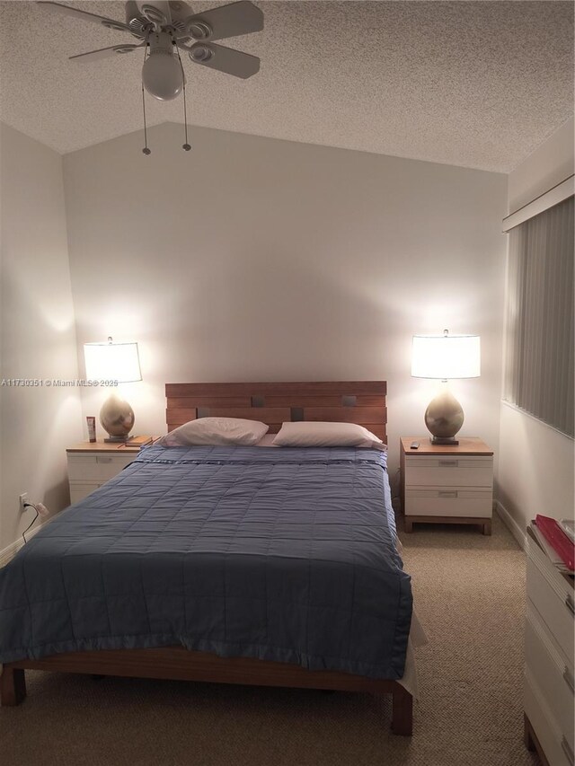 carpeted bedroom featuring vaulted ceiling, a textured ceiling, and ceiling fan