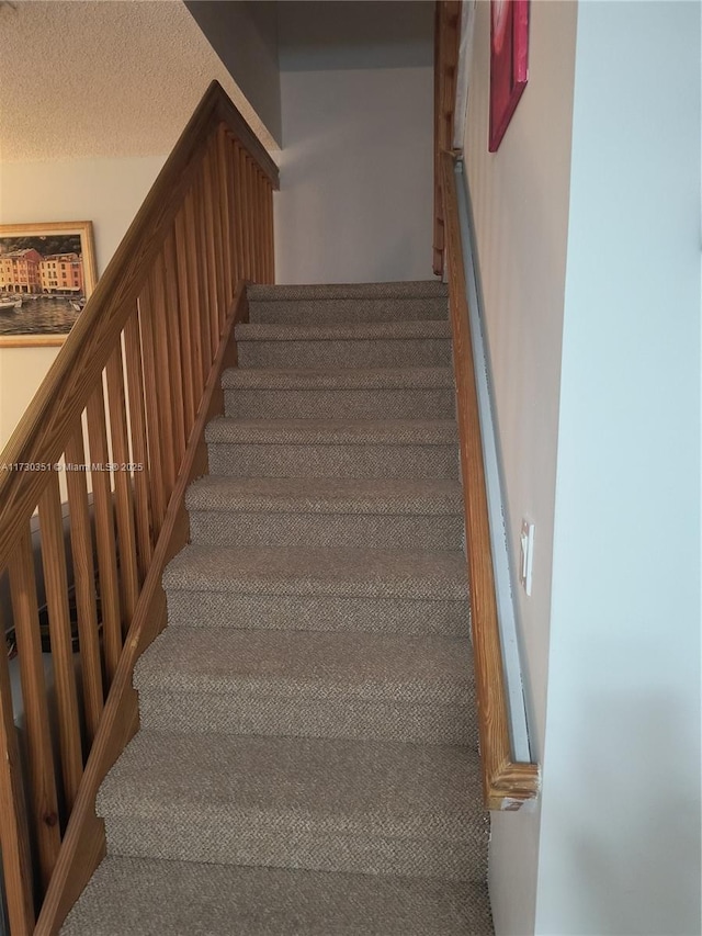 stairway with a textured ceiling