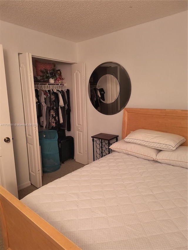 carpeted bedroom with a closet and a textured ceiling