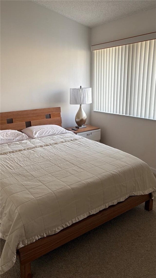 carpeted bedroom featuring a textured ceiling