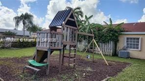 view of playground with central AC and a lawn