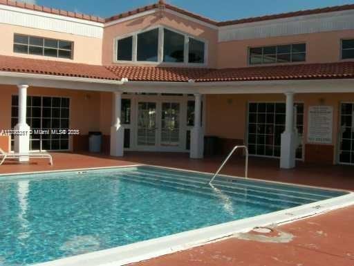 rear view of property featuring a patio and a community pool