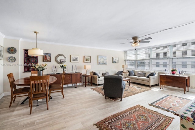 living room with ornamental molding, light hardwood / wood-style floors, and ceiling fan