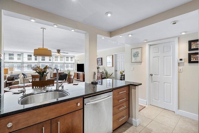 kitchen featuring dark stone counters, decorative light fixtures, dishwasher, and sink