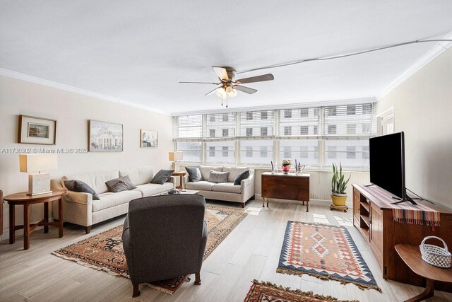 living room featuring ceiling fan, ornamental molding, and light hardwood / wood-style flooring