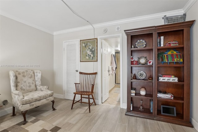 living area featuring crown molding and light hardwood / wood-style flooring