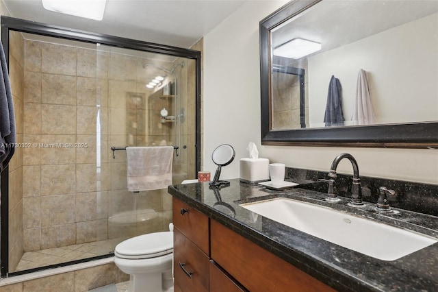 bathroom with vanity, toilet, and a shower with shower door