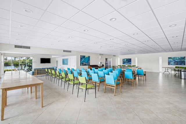 tiled dining space featuring a paneled ceiling