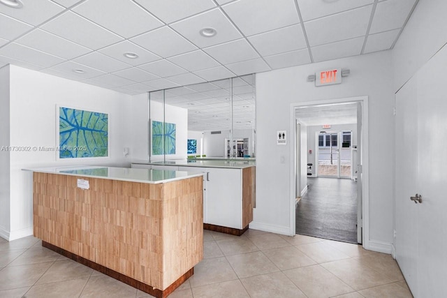 kitchen featuring white cabinetry, kitchen peninsula, and light tile patterned floors