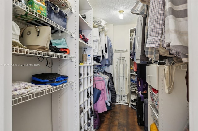 walk in closet featuring dark parquet flooring