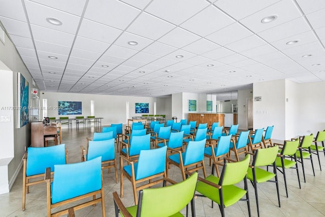 interior space featuring a paneled ceiling and light tile patterned floors