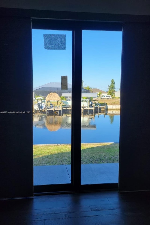 doorway to outside featuring a water view and wood-type flooring