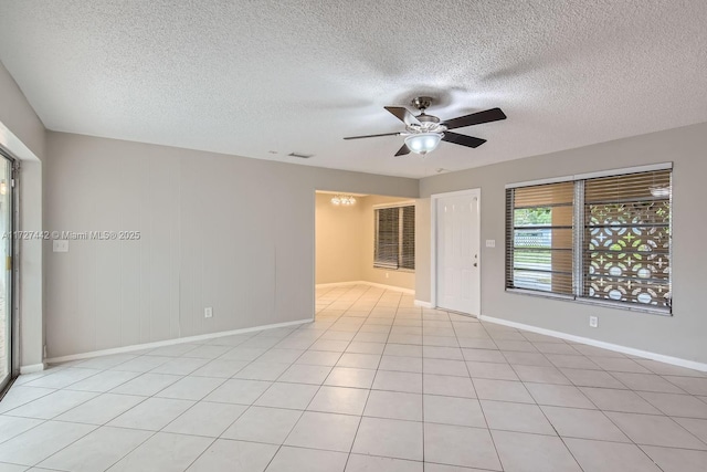 spare room with ceiling fan, light tile patterned floors, and a textured ceiling