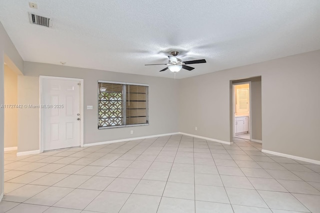 unfurnished room featuring a textured ceiling, light tile patterned floors, and ceiling fan