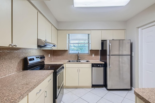 kitchen featuring sink, backsplash, light tile patterned floors, and appliances with stainless steel finishes