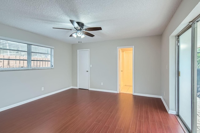 empty room featuring ceiling fan, a textured ceiling, and dark hardwood / wood-style flooring