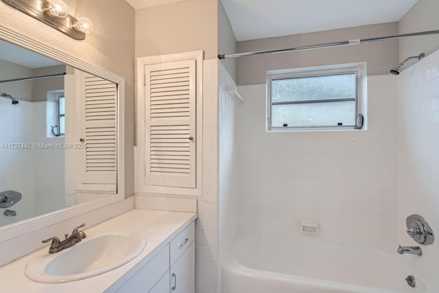 bathroom with tiled shower / bath and vanity