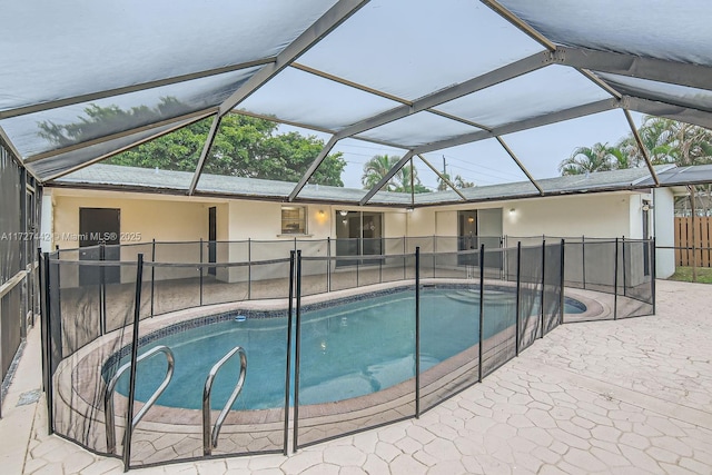 view of swimming pool with a patio area and glass enclosure