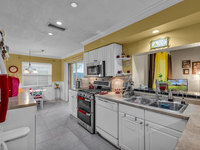 kitchen featuring white cabinets, stainless steel appliances, sink, hanging light fixtures, and ornamental molding